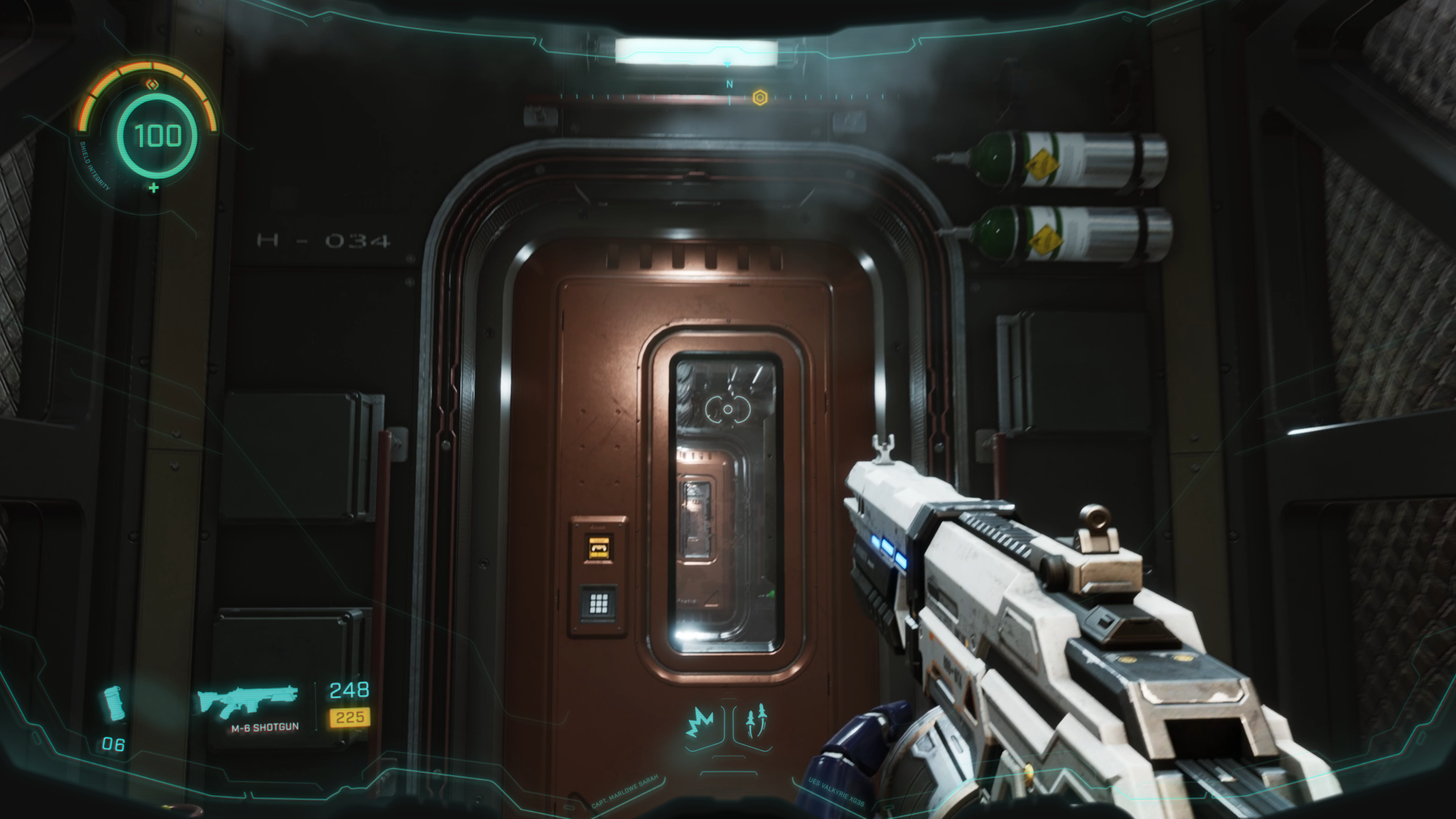 Full in-game HUD with shield gauge, compass, weapon info, and abilities in a sci-fi corridor
